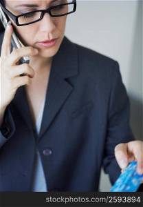 Businesswoman talking on a mobile phone and holding a credit card