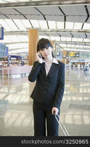 Businesswoman talking on a mobile phone at an airport lounge