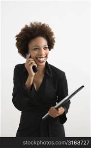 Businesswoman talking on cellphone smiling against white background.