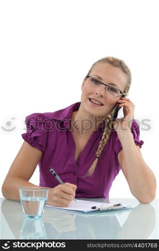businesswoman talking on her cell and taking notes