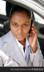 Businesswoman talking on her mobile phone in her car