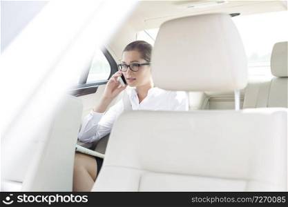 Businesswoman talking on smartphone while sitting in car 