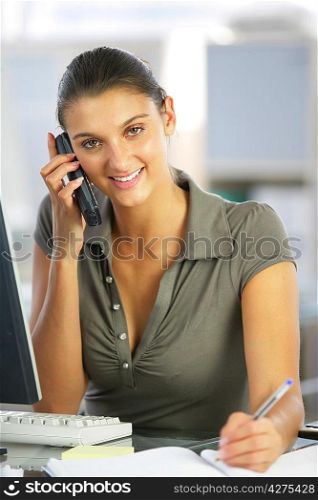 businesswoman talking on the phone and taking notes
