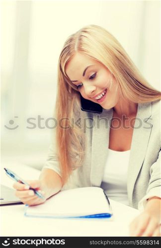 businesswoman talking on the phone and taking notes