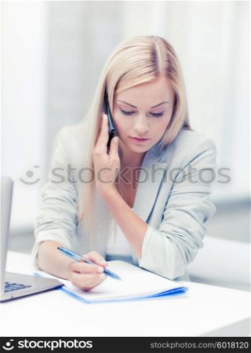 businesswoman talking on the phone and taking notes. businesswoman with phone