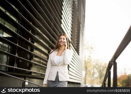 Businesswoman talking on the phone near office building