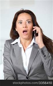businesswoman talking on the phone with surprised look