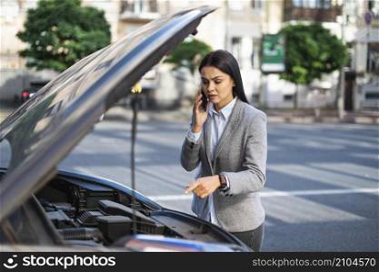 businesswoman talking phone while her car broke down