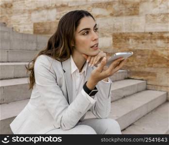 businesswoman talking phone while sitting outdoors
