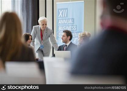 Businesswoman talking to colleagues during seminar