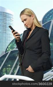 Businesswoman text messaging outside office building