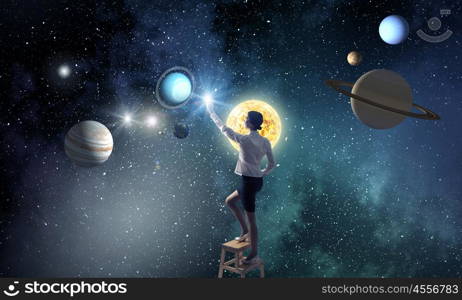 Businesswoman touch planet in sky. Businesswoman standing on chair and reaching space planets