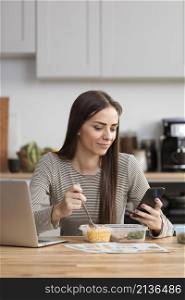 businesswoman trying eat work from her phone