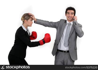 Businesswoman trying to box a man on a phone