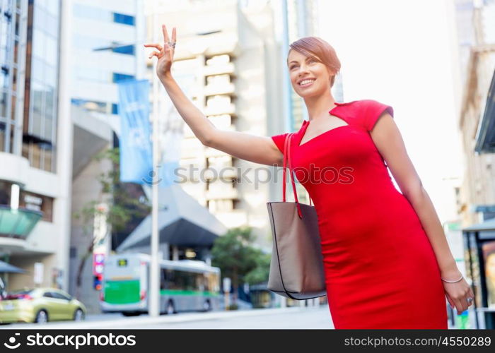 Businesswoman trying to catch a taxi. Businesswoman trying to catch a taxi in business city district