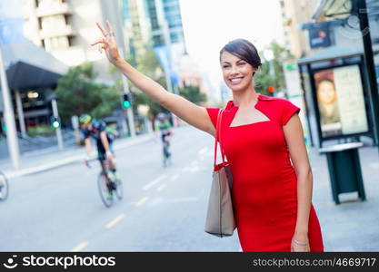 Businesswoman trying to catch a taxi. Businesswoman trying to catch a taxi in business city district