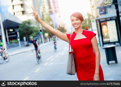 Businesswoman trying to catch a taxi. Businesswoman trying to catch a taxi in business city district