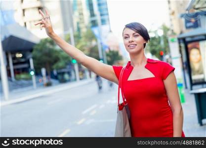 Businesswoman trying to catch a taxi. Businesswoman trying to catch a taxi in business city district