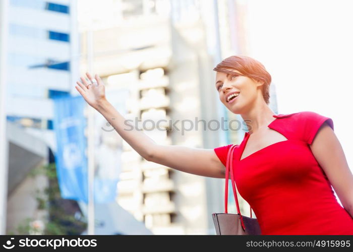 Businesswoman trying to catch a taxi. Businesswoman trying to catch a taxi in business city district