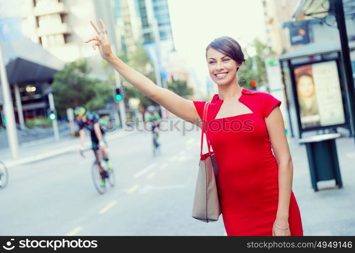 Businesswoman trying to catch a taxi. Businesswoman trying to catch a taxi in business city district