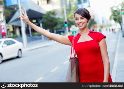 Businesswoman trying to catch a taxi. Businesswoman trying to catch a taxi in business city district