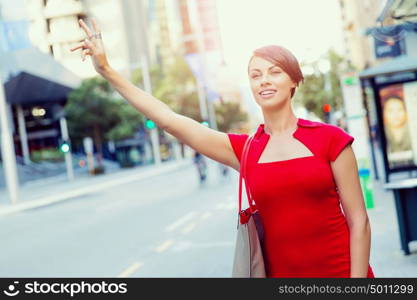 Businesswoman trying to catch a taxi. Businesswoman trying to catch a taxi in business city district