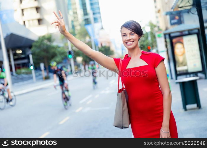 Businesswoman trying to catch a taxi. Businesswoman trying to catch a taxi in business city district