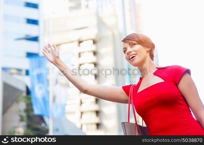 Businesswoman trying to catch a taxi. Businesswoman trying to catch a taxi in business city district