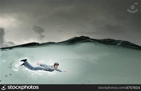 Businesswoman under water. Young businessman in suit swimming in crystal blue water