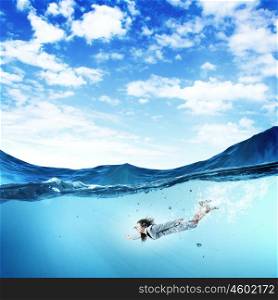 Businesswoman under water. Young businesswoman in suit swimming in crystal blue water