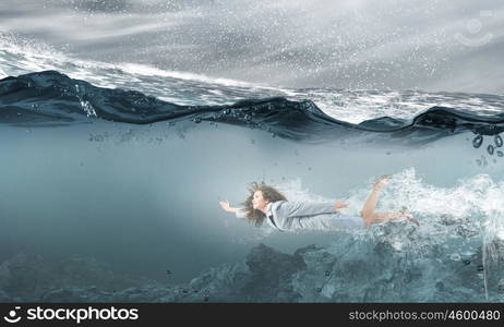 Businesswoman under water. Young businesswoman in suit swimming in stormy waters