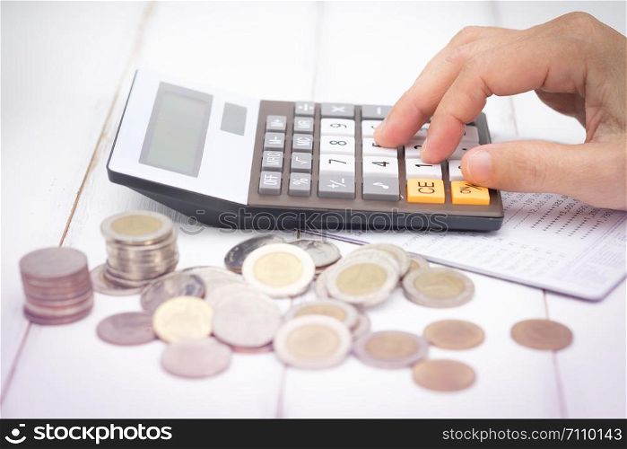 Businesswoman using a calculator have saving Account Book from Bank for Business Finance with pen, calculator and coin on desk, Choose focus point.