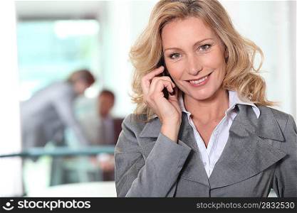 Businesswoman using a cellphone in an office
