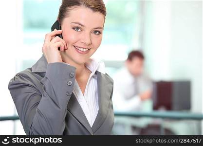 Businesswoman using a cellphone in an office