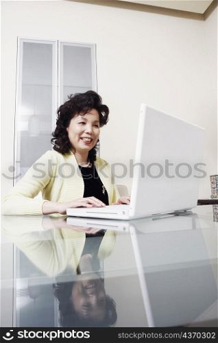 Businesswoman using a laptop smiling