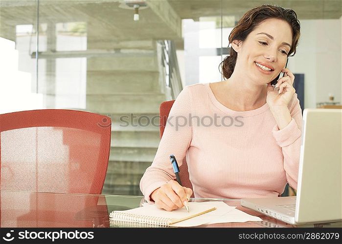 Businesswoman Using Cell Phone and Laptop