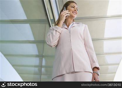 Businesswoman using cell phone on balcony