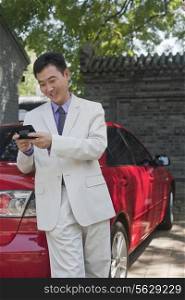 Businesswoman Using Cell Phone While Leaning on Car