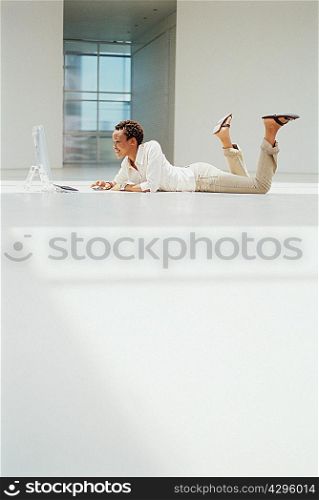 Businesswoman using computer on floor
