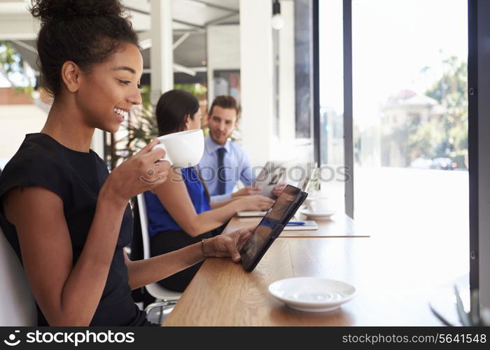 Businesswoman Using Digital Tablet In Coffee Shop