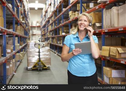 Businesswoman Using Digital Tablet In Distribution Warehouse