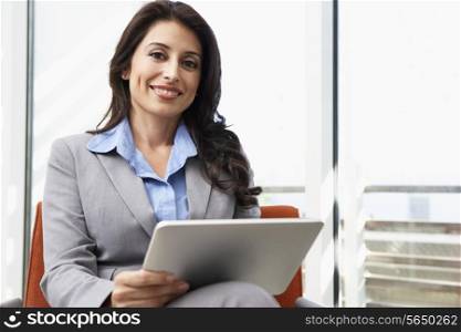 Businesswoman Using Digital Tablet In Office