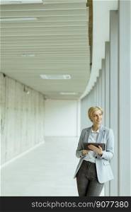 Businesswoman using digital tablet on the modern office hallway