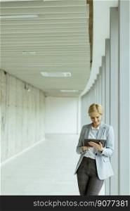 Businesswoman using digital tablet on the modern office hallway