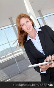 Businesswoman using electronic tablet outside