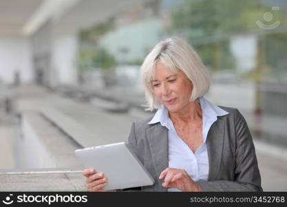 Businesswoman using electronic tablet outside airport