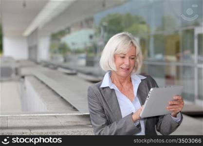 Businesswoman using electronic tablet outside airport