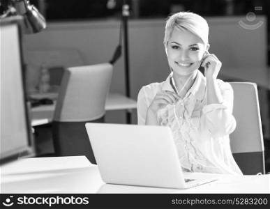 Businesswoman using headset and smiling at work