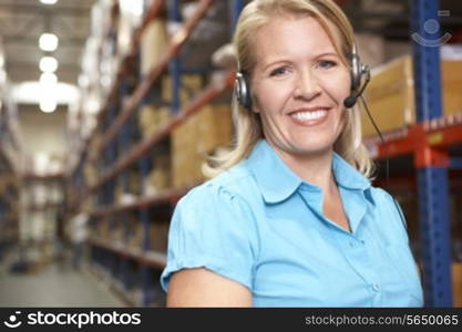 Businesswoman Using Headset In Distribution Warehouse