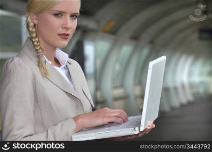 Businesswoman using her laptop at the train station